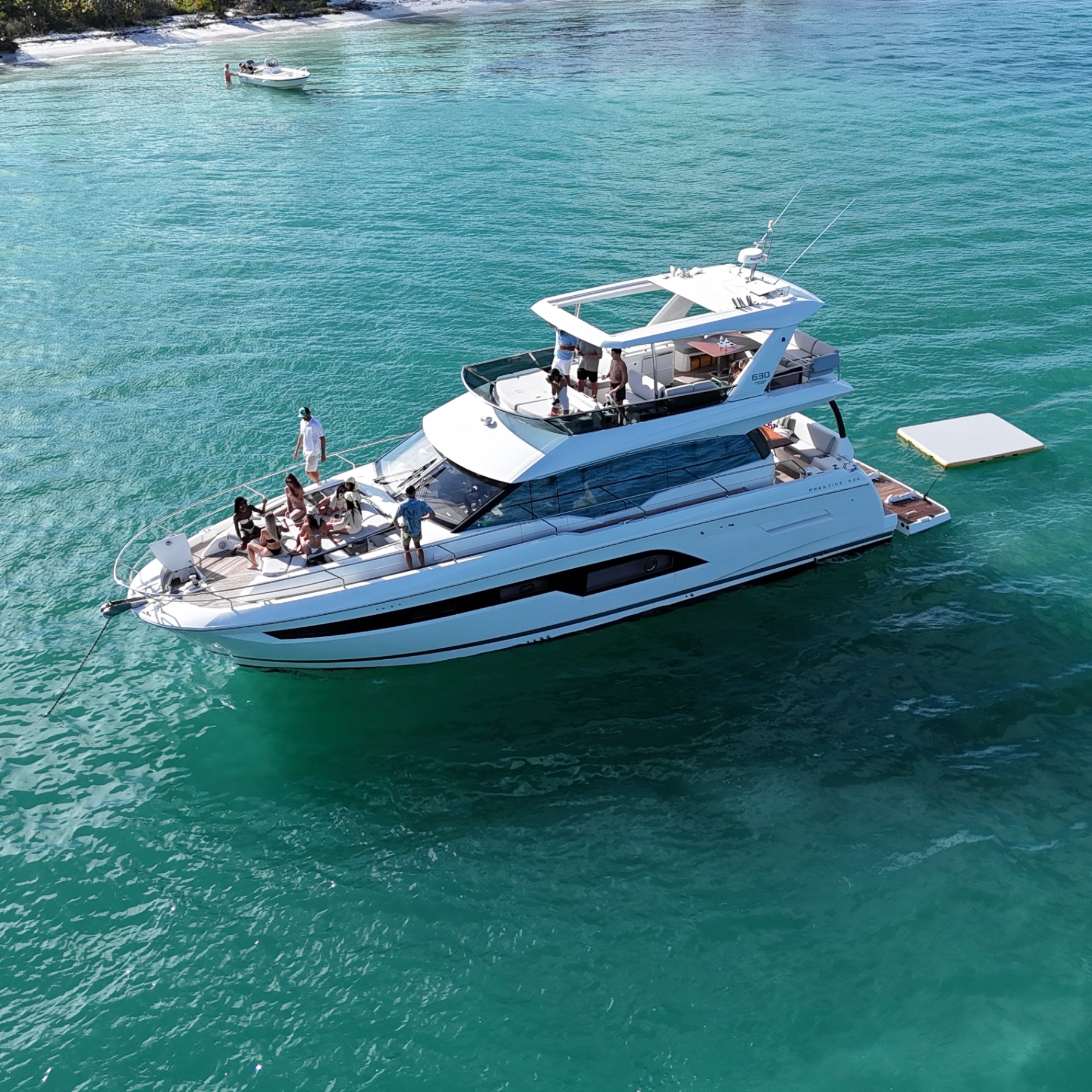 Luxury Prestige 630 yacht anchored at a Sarasota sandbar with guests onboard